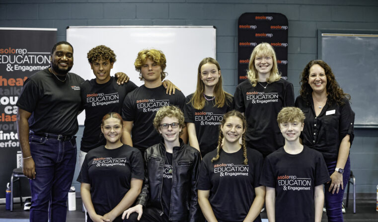 Two adults pose with a group of teens wearing Asolo Rep Education & Engagement shirts.