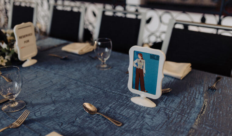 A set tablescape with a Lady MC Scotland graphic in a picture frame.