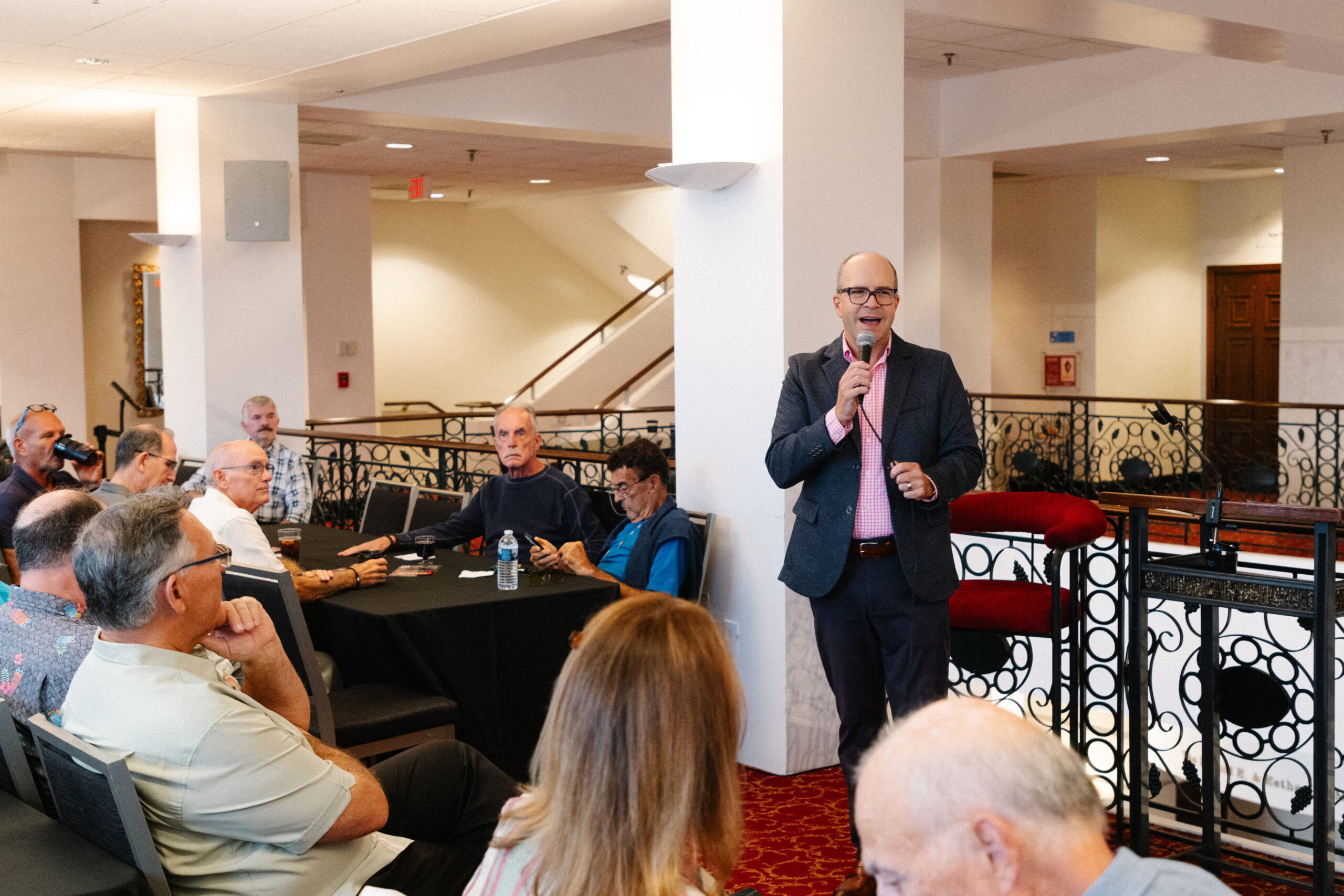 man standing in front of a group talking into a microphone