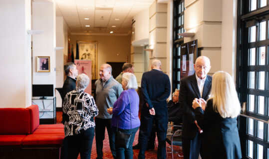 group of people standing around at an event talking