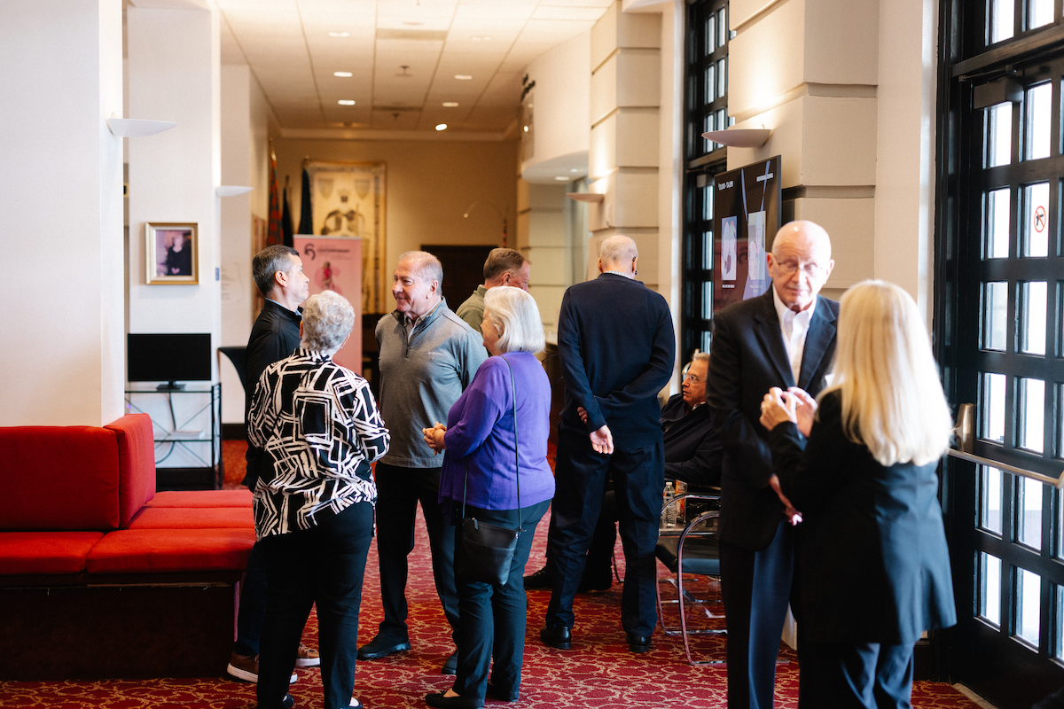 group of people standing around at an event talking