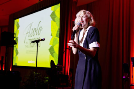 A woman singing into a standing microphone at Asolo Rep's Annual Gala.