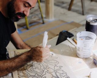 A man working on plaster detailing for a set.