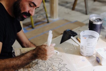 A man working on plaster detailing for a set.