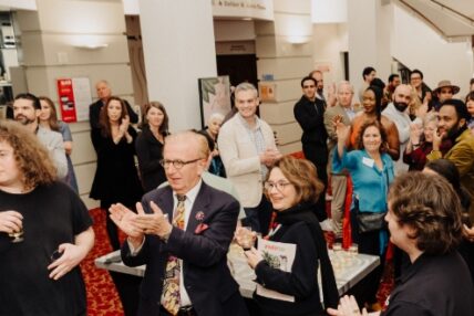 Corporate event attendees applauding.