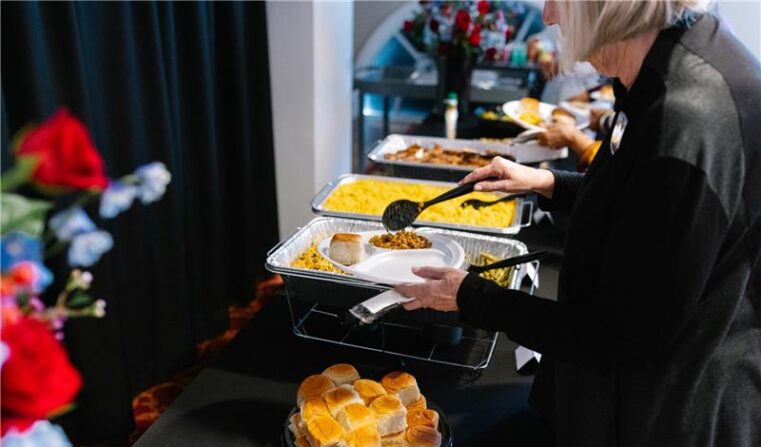 Theatre patron puts food onto a plate.