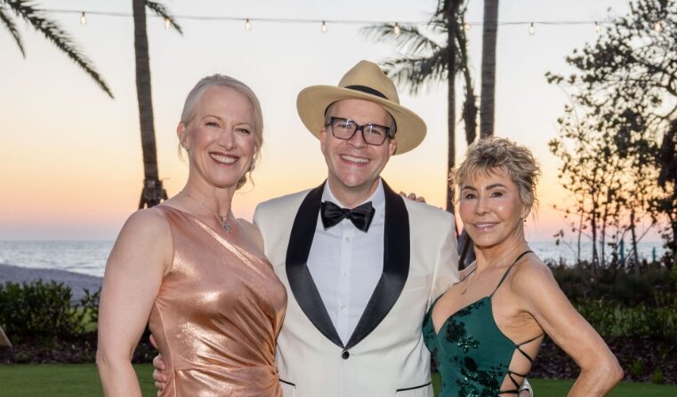 A man in a hat posing with two women in dresses at an Asolo Rep's Annual Gala.