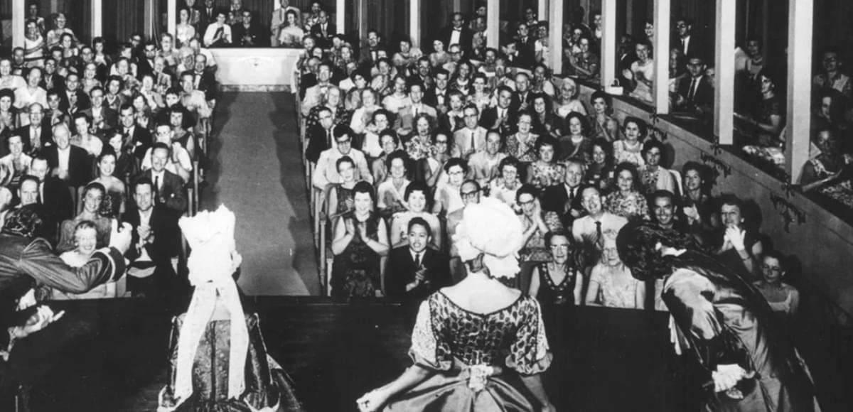 Historic photo shot from behind actors on the Asolo Rep stage with the audience in the background