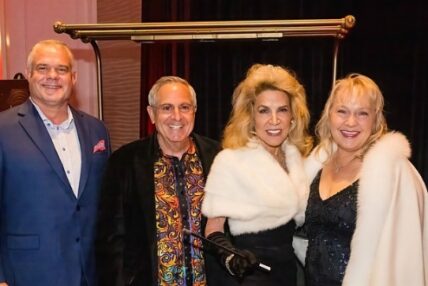 Two men and two women pose in fancy attire.