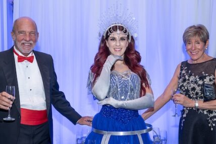 Two patrons pose with a performer in costume at Asolo Rep's 2024 Annual Gala.