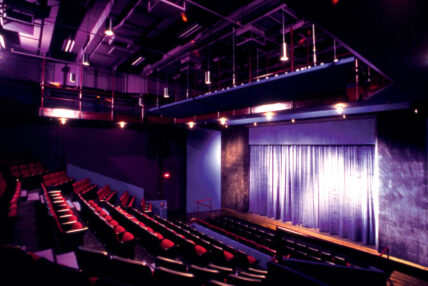 Theatre seats and a stage, both empty.