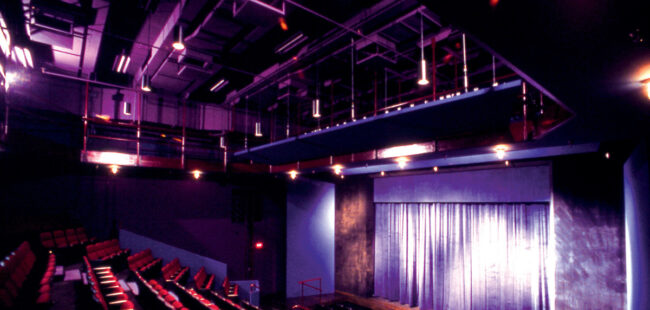 Theatre seats and a stage, both empty.
