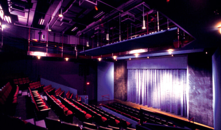 Theatre seats and a stage, both empty.