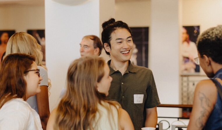 A group of young adults talk and smile.