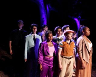 A group of men and women standing together singing.