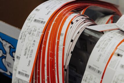 Rolls of ticket ribbons draped over the edge of a container.