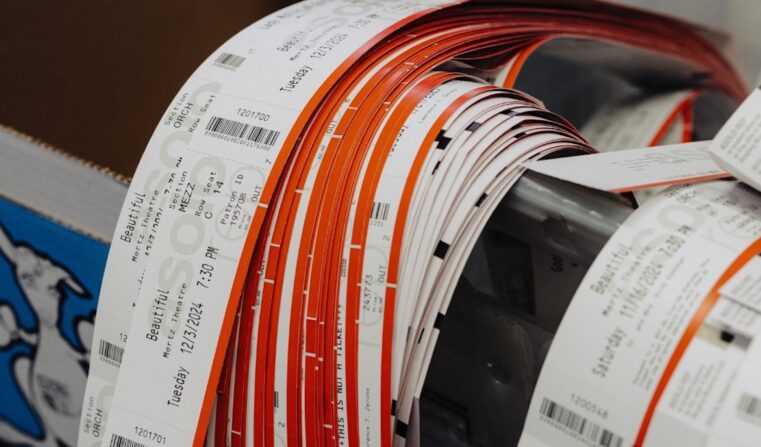 Rolls of ticket ribbons draped over the edge of a container.
