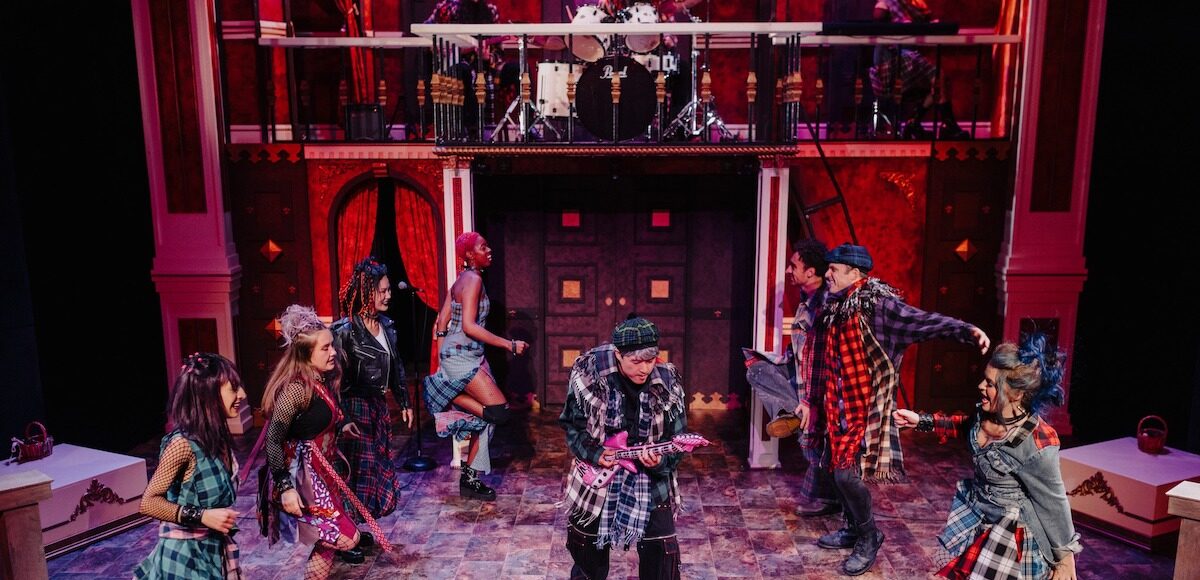 Eight performers in full grunge-punk costumes dancing on stage.