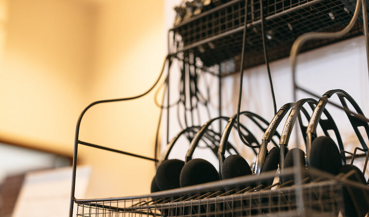 wire rack holding numerous sets of Koss headphones