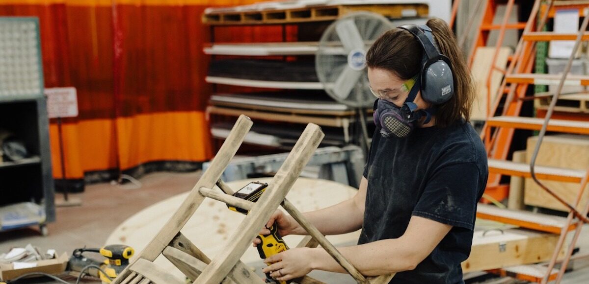 A woman building a wooden chair.