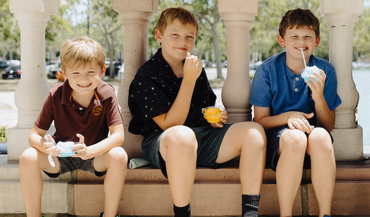 Three young boys smiling and holding frozen treats at an Asolo Rep youth camp.