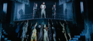 people standing on a decorated stage for a performance