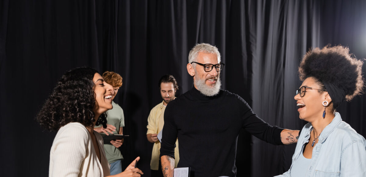 Adults in a theatre setting talking to each other