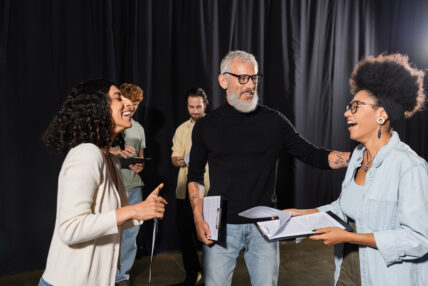Adults in a theatre setting talking to each other